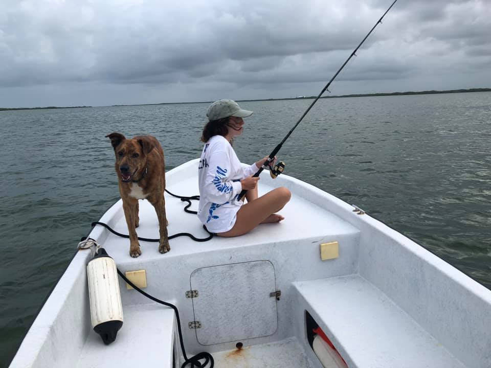 Woman fishing on boat with do